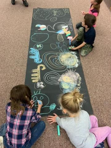 Ms. Nilson's students coloring with chalk