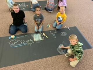 students using chalk on paper.