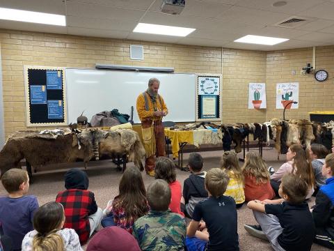 mountain man sharing his tools with the 4th graders