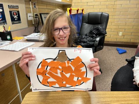 Student showing off halloween art work